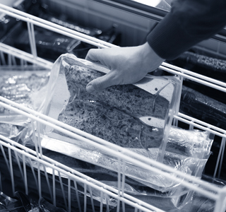 Verpackter Fisch wird aus Kühltruhe genommen