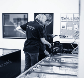 Räucherei-Mitarbeiter berät Kunden